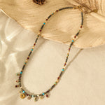 Necklace with multicolored beads and charms on a textured beige surface