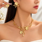 Gold necklace and earrings on a model with a neutral background