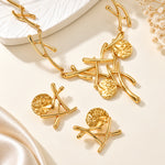 Gold necklace with leaf-like pendants on a beige background