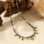 Necklace with beads and charms on a textured surface