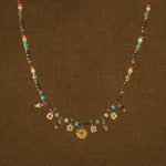 Necklace with multicolored beads and floral charms on a brown background